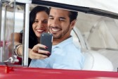9749840-happy-young-man-and-woman-smiling-while-taking-snapshot-with-cell-phone-camera-from-red-vintage-conv